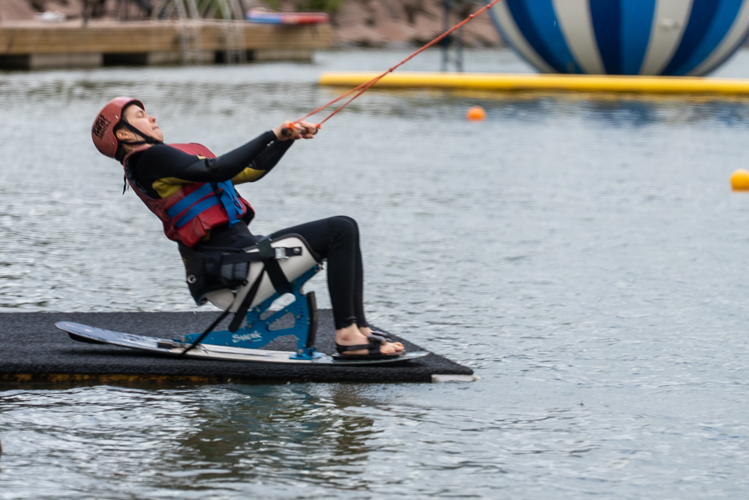 Kuvassa henkilö lähtee sitwake laudalla liikkeelle kaapelin vetämänä wakeboardradan lähtöalustalta.